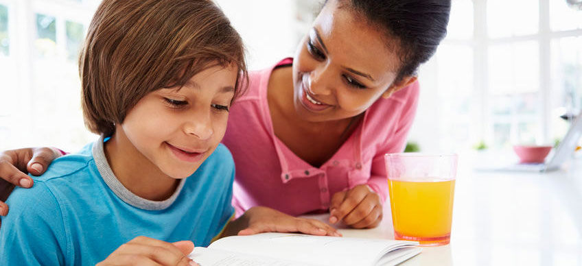 Mom helping student read at home.